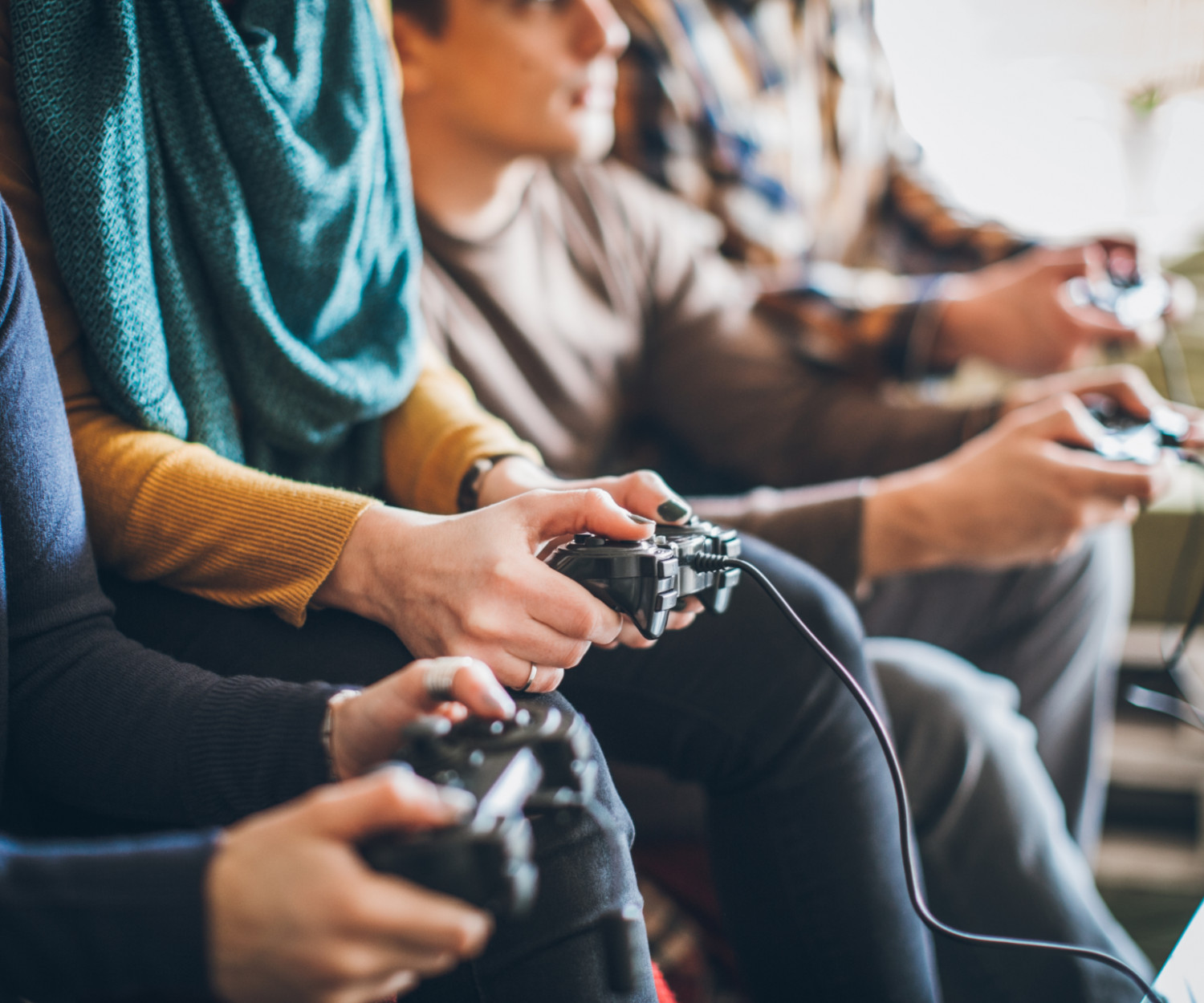 Group of young happy friends playing video games at home.